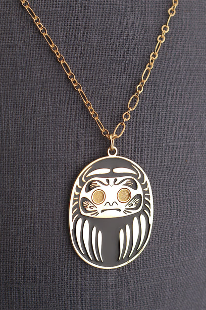 Collana Daruma Nera con ciondolo oro su sfondo grigio – simbolo successo e protezione contro le avversità Nuage d'Étoiles

