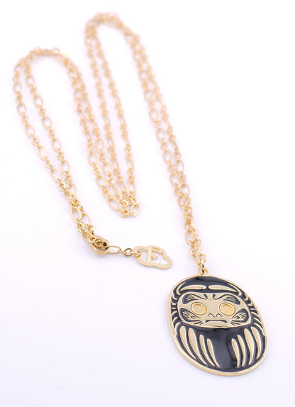 Collana con ciondolo Daruma nero e oro su sfondo bianco – Nuage d'Étoiles