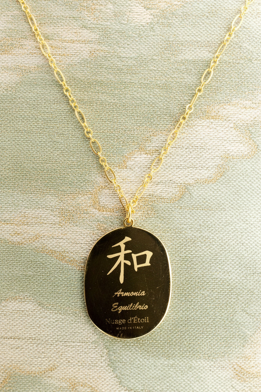 Gold necklace with a pendant featuring Japanese characters on a green background