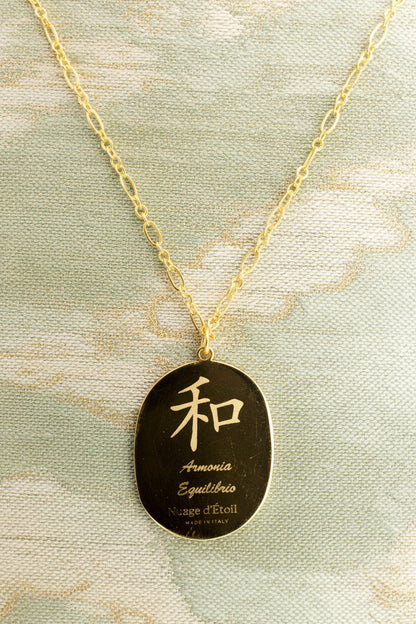 Gold necklace with a pendant featuring Japanese characters on a green background